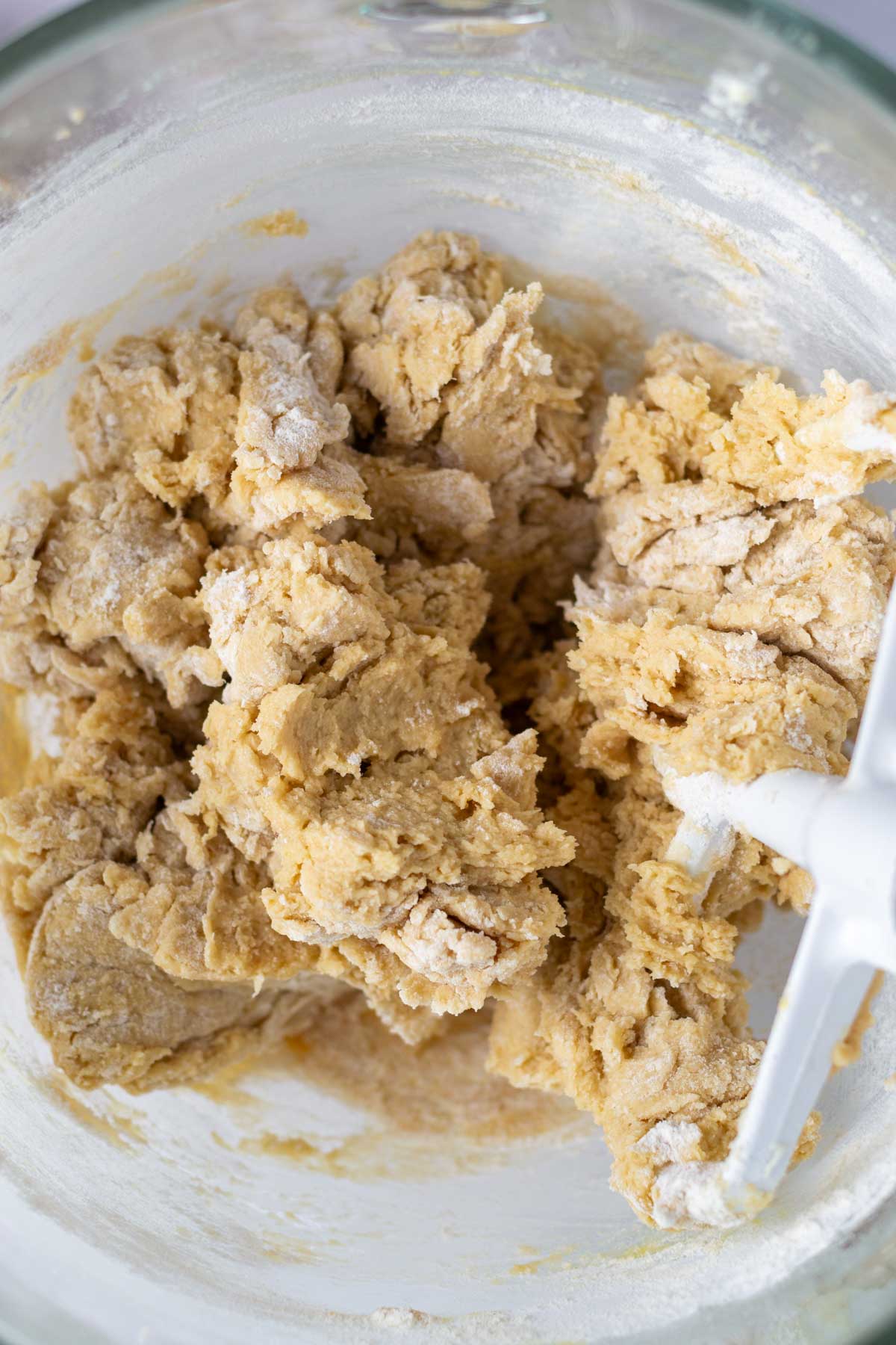cookie dough in a mixing bowl with some flour showing