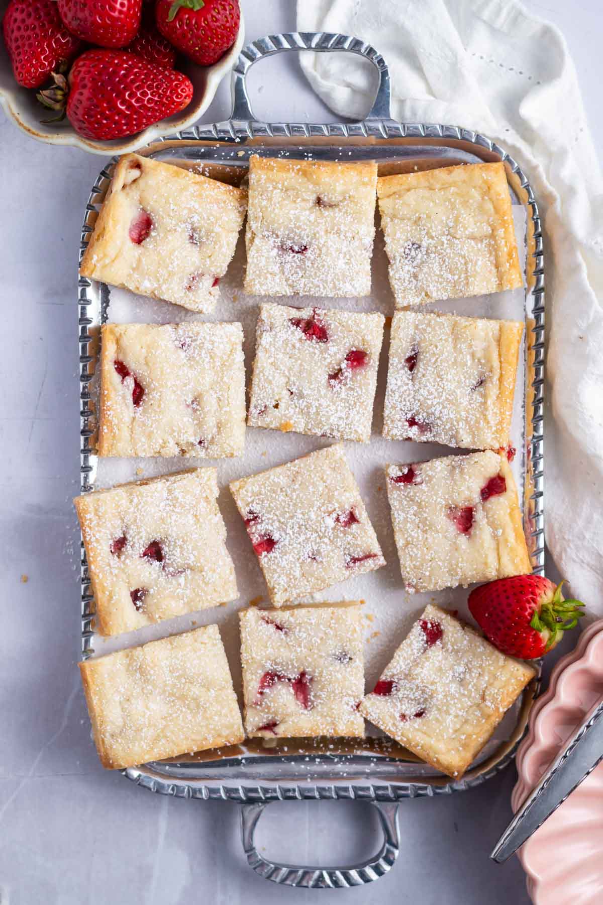strawberry blondies dusted with powdered sugar on a serving tray