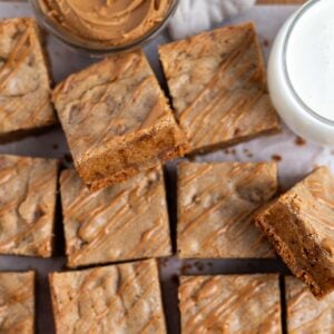 biscoff blondies showing chewy inside texture on parchment paper with a glass of milk
