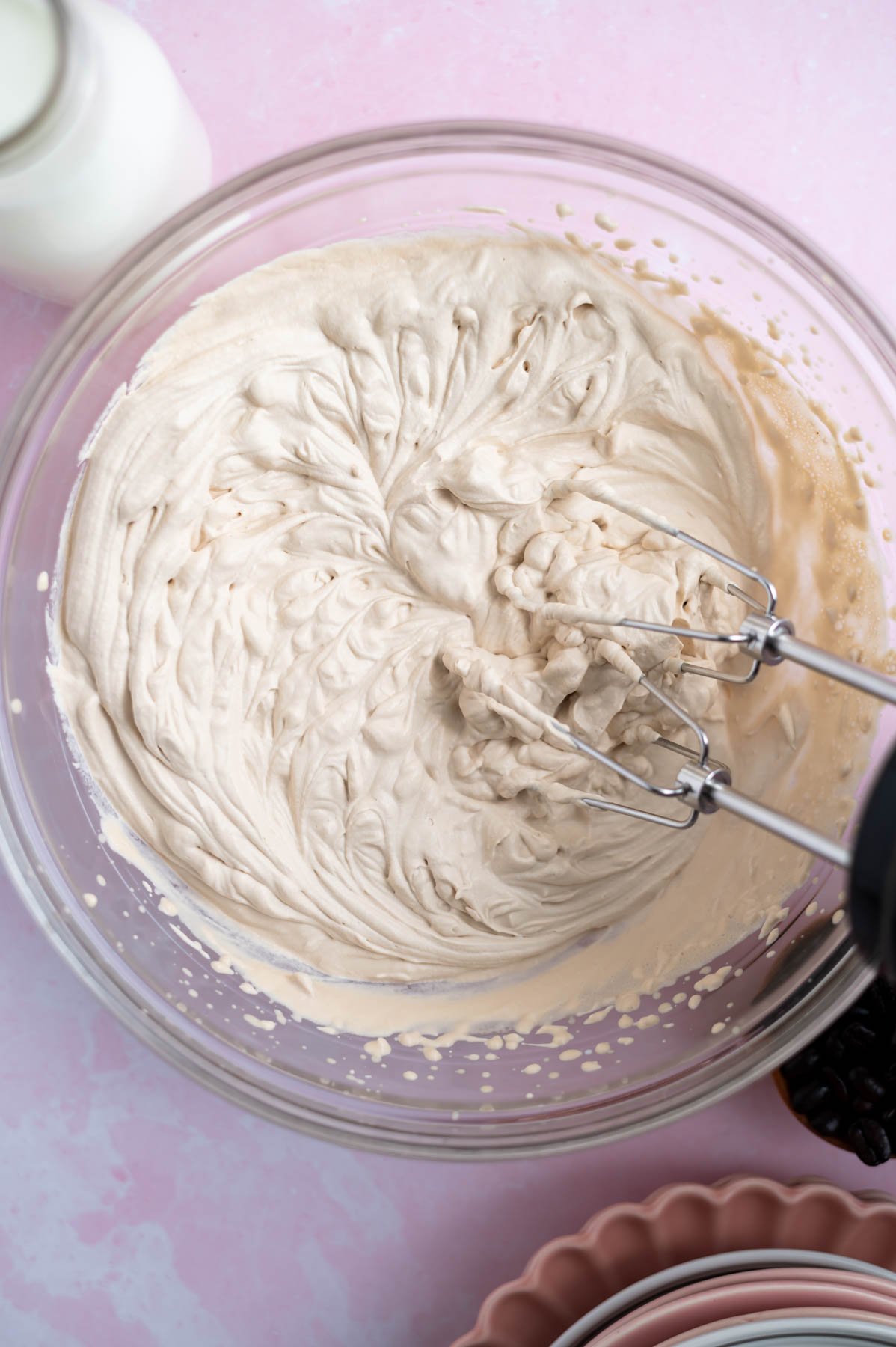 espresso whipped cream in a mixing bowl with a hand mixer