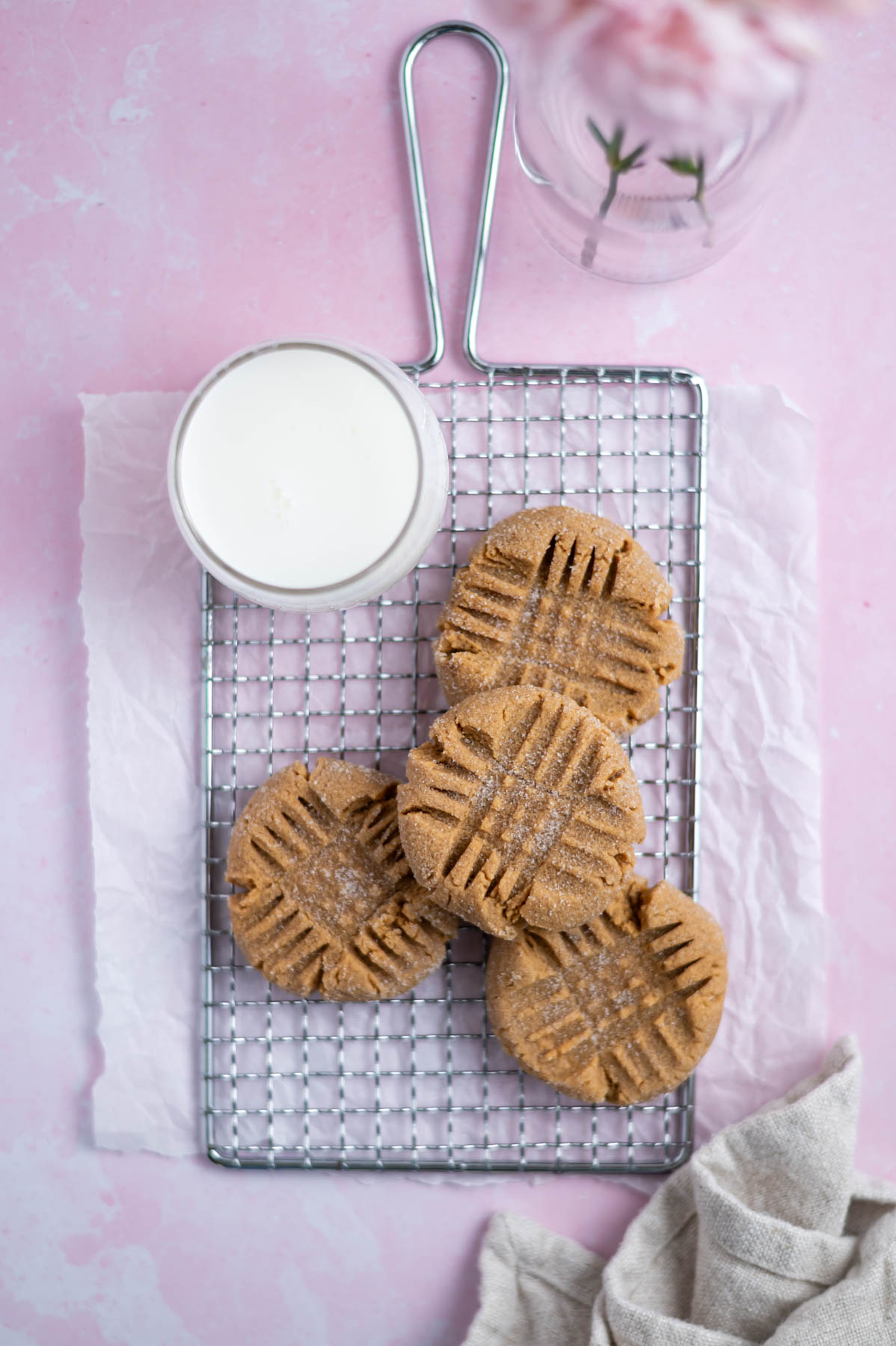 small batch peanut butter cookies on a cooling rack with a glass of milk and a napkin