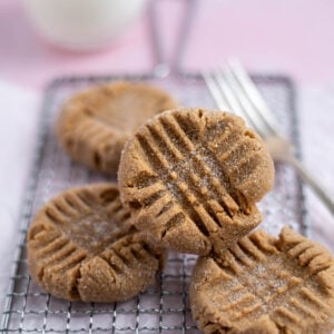 four small batch peanut butter cookies on a cooling rack with a fork
