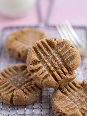 four small batch peanut butter cookies on a cooling rack with a fork