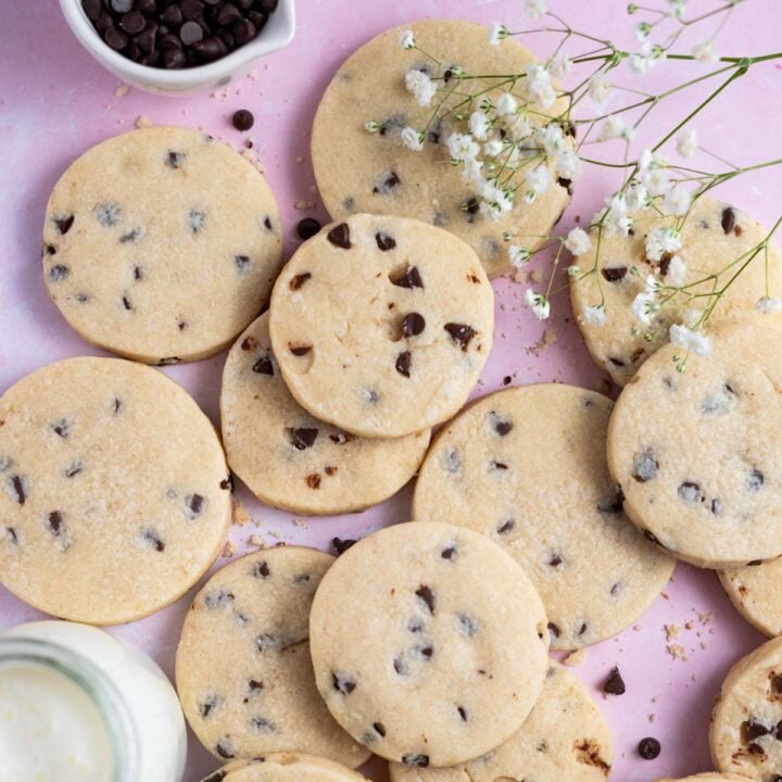 chocolate chip sugar cookies with a bowl of chocolate chips and a glass of milk