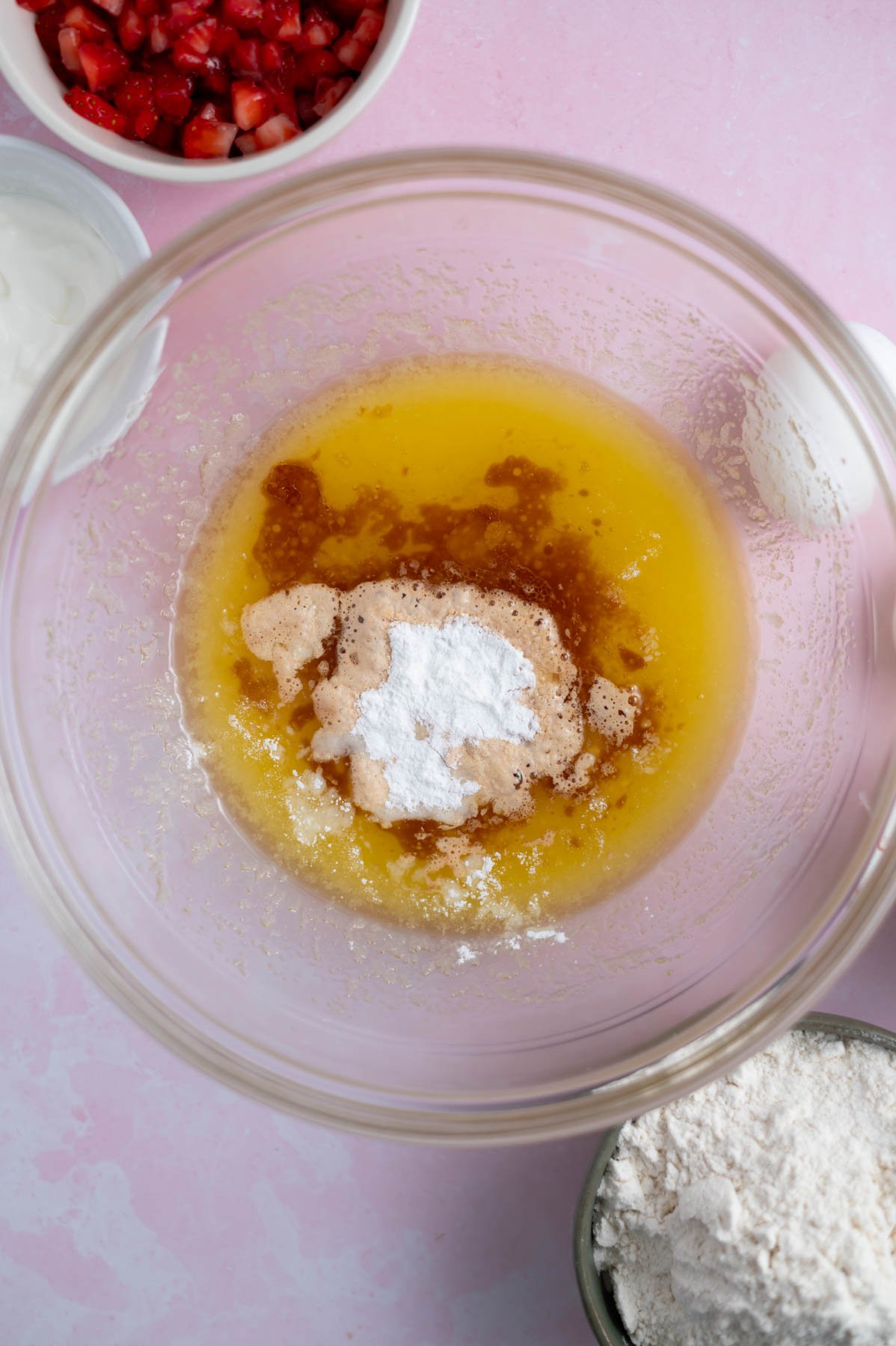 vanilla and baking powder added to melted butter and sugar in a mixing bowl