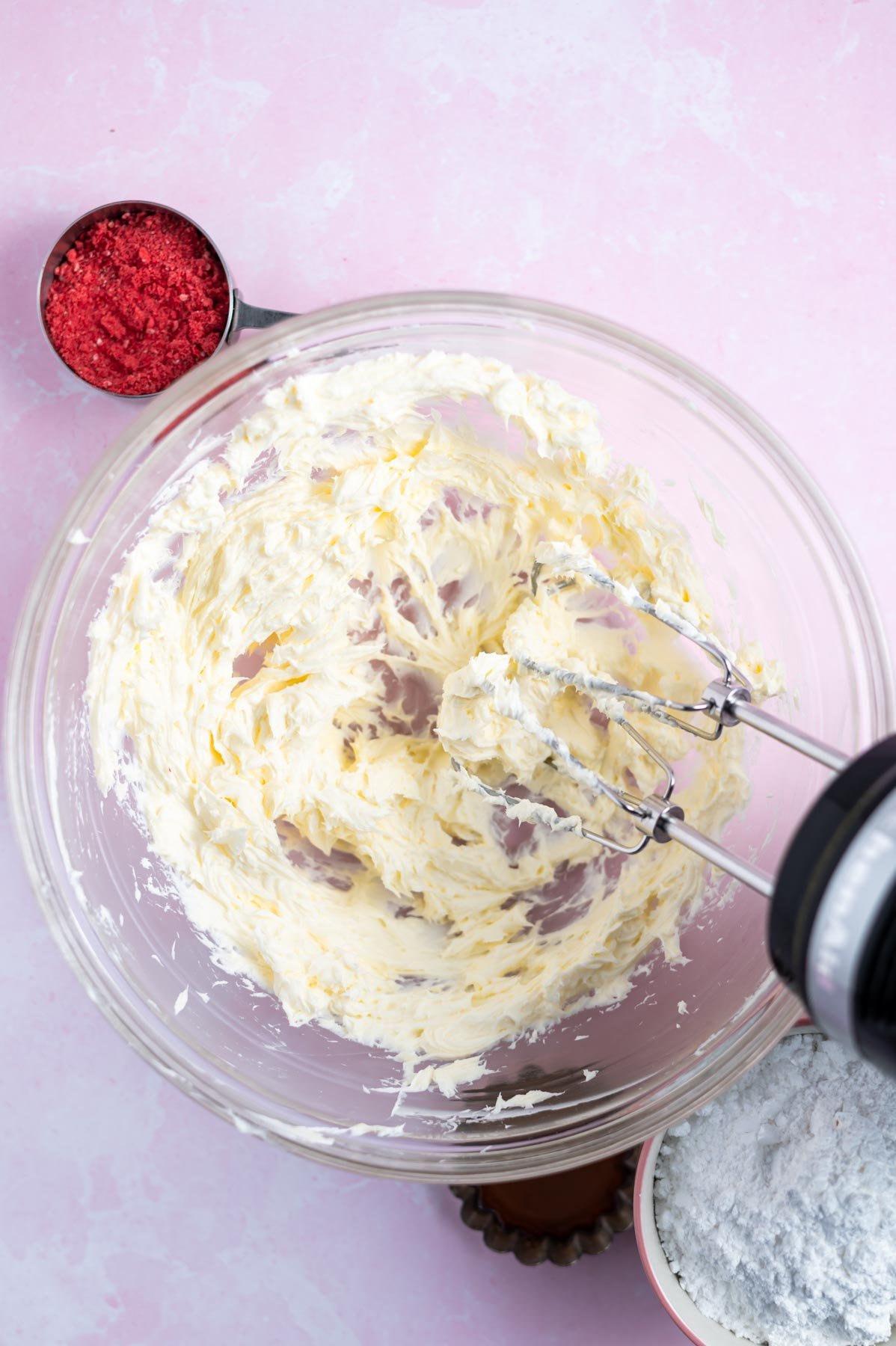 cream cheese and butter creamed together in a mixing bowl with a hand mixer