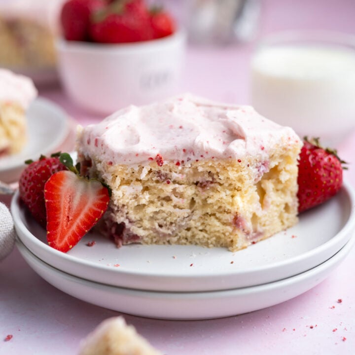 slice of strawberry snack cake on a plate with a bite missing