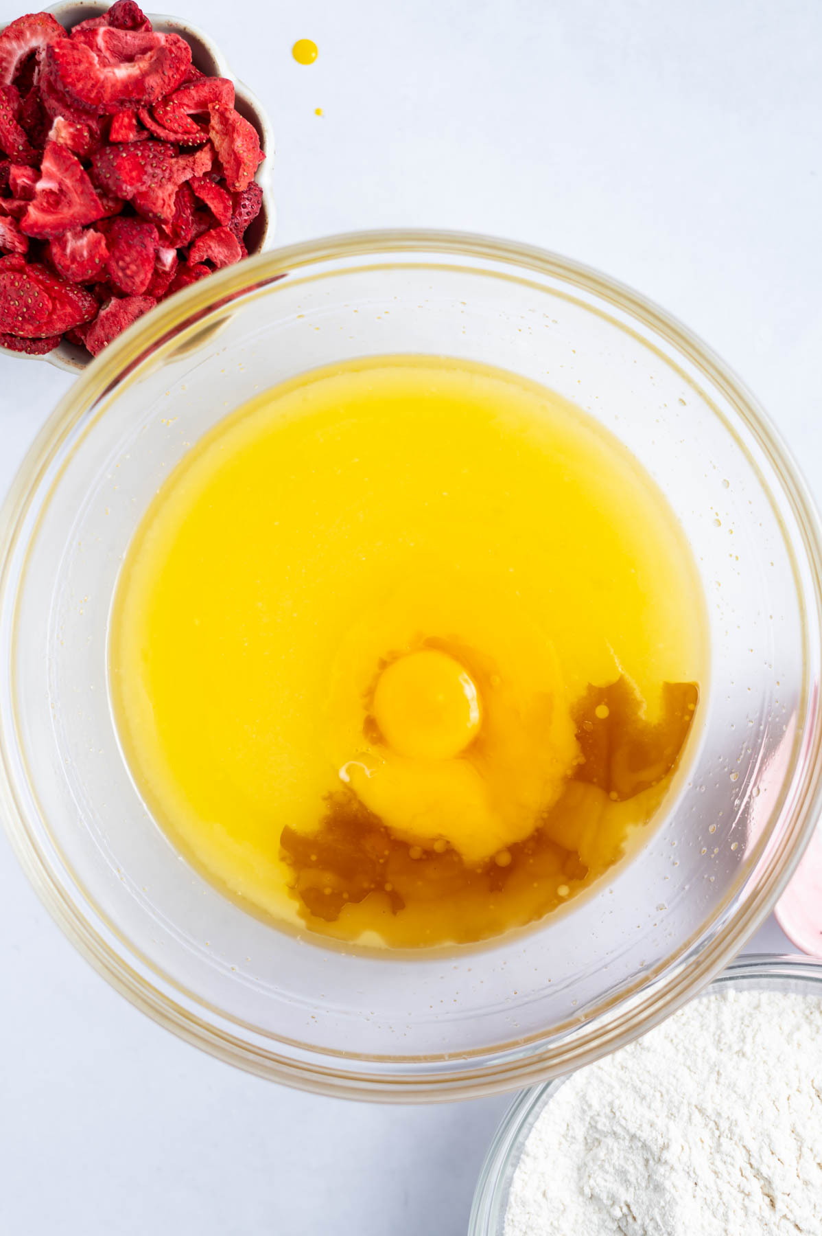 egg yolk and vanilla added to melted butter and sugar in a bowl