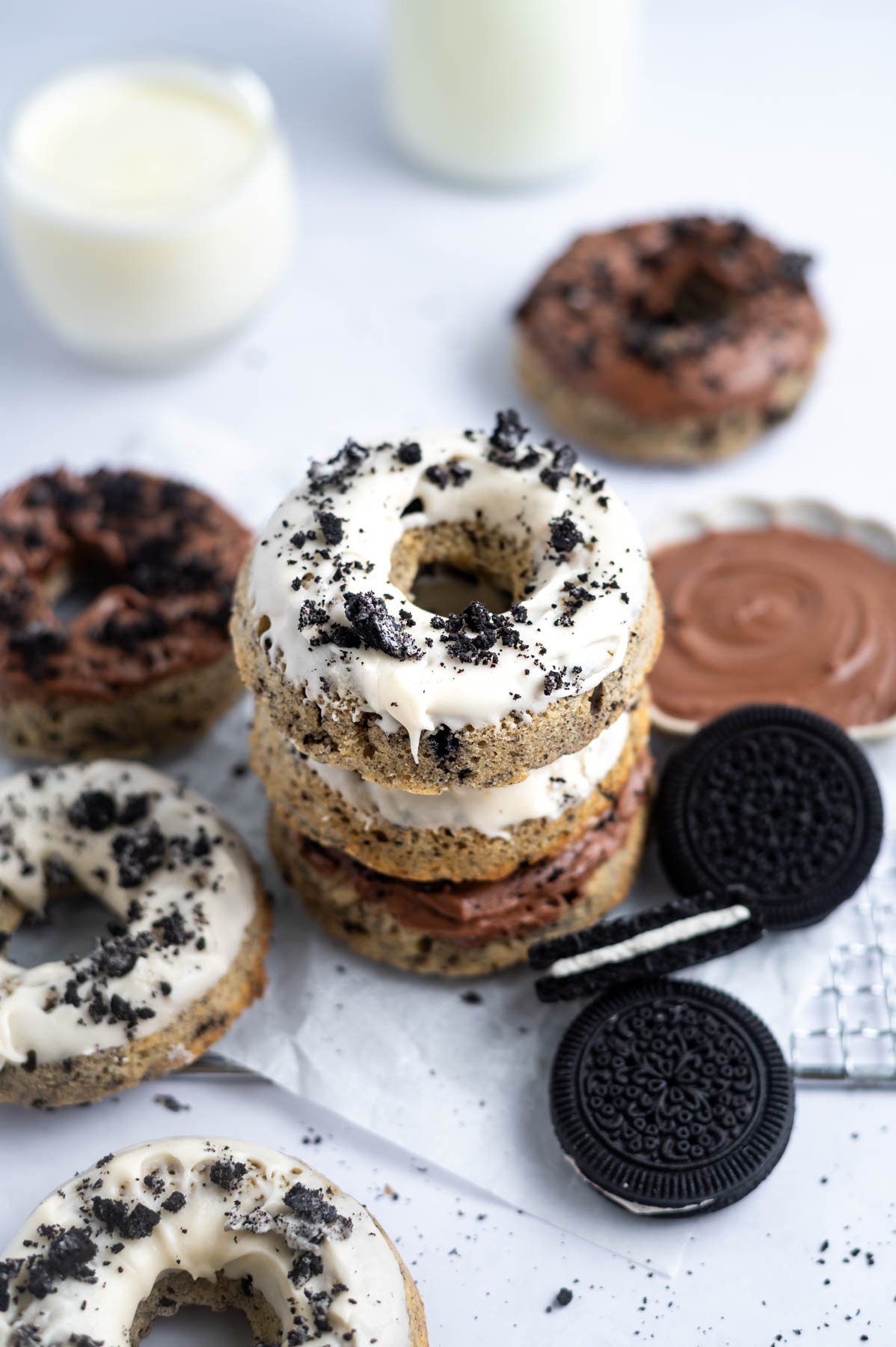 stack of donuts with extra glaze in a bowl and milk glasses