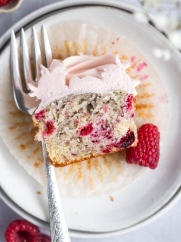 raspberry cupcake showing soft crumb interior on a plate with a fork