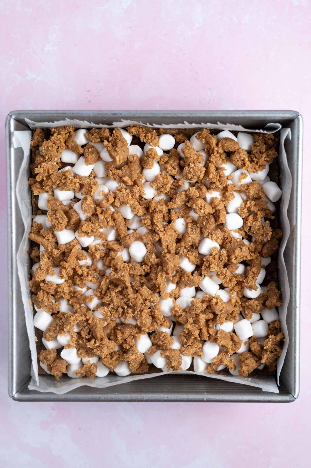 graham crumble added over mini marshmallows in a baking tin