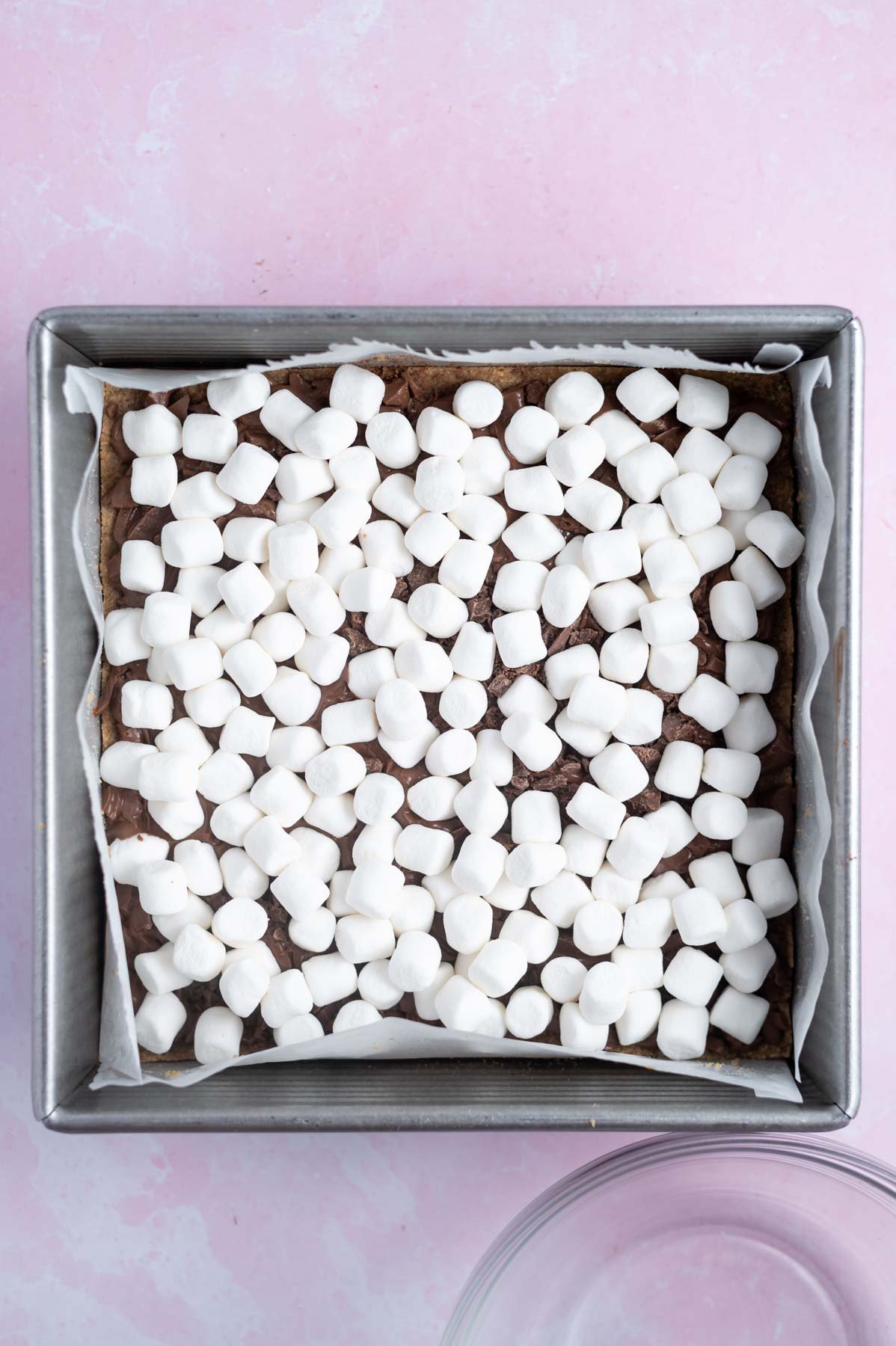 layer of mini marshmallows added to dessert bars in a baking pan