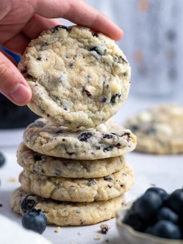 hand grabbing a blueberry white chocolate cookie