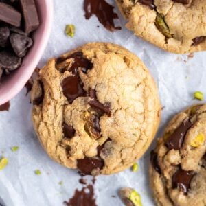 pistachio chocolate chip cookies with melty chocolate on parchment paper