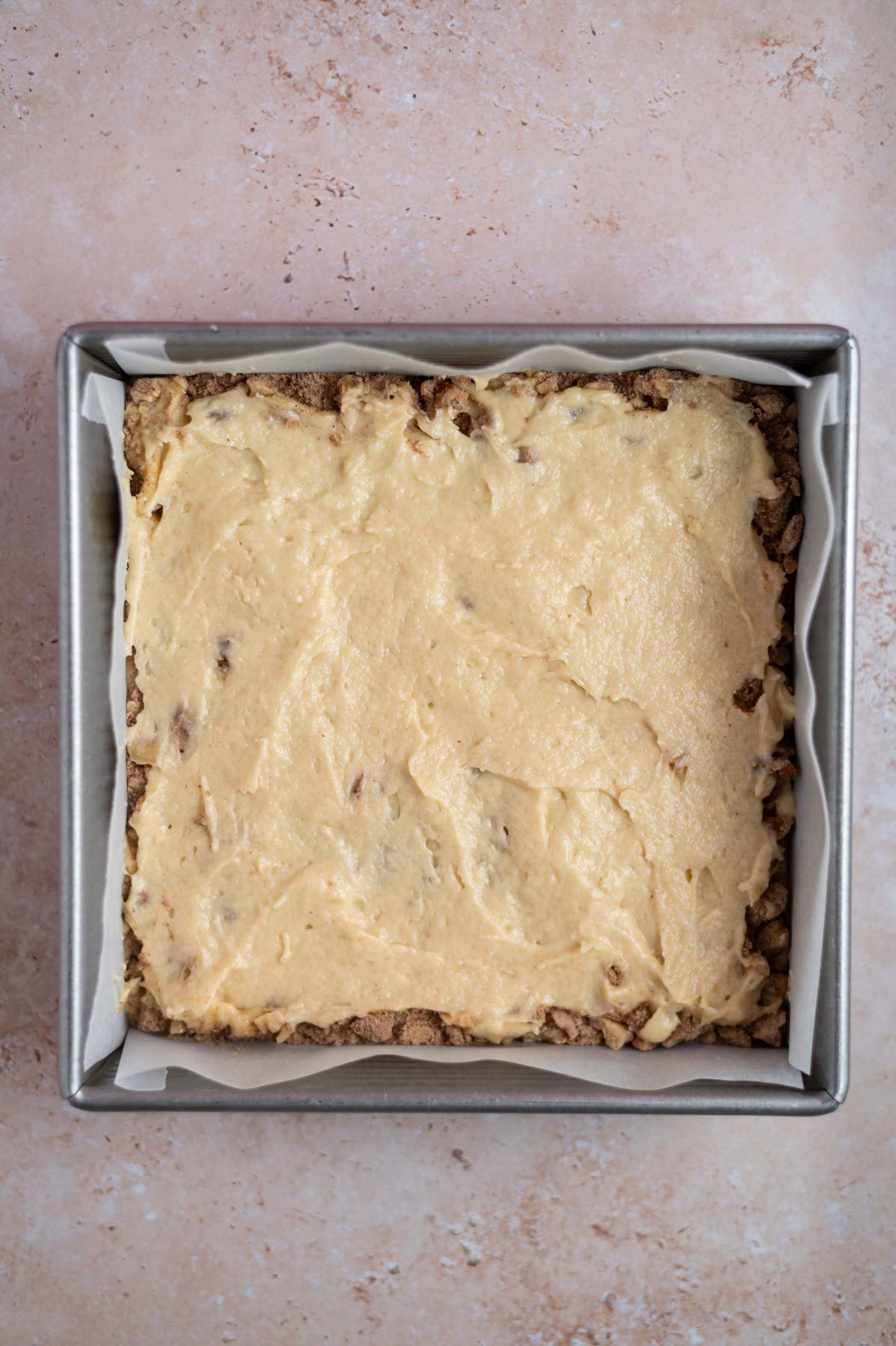 cake batter over streusel layer in a baking pan