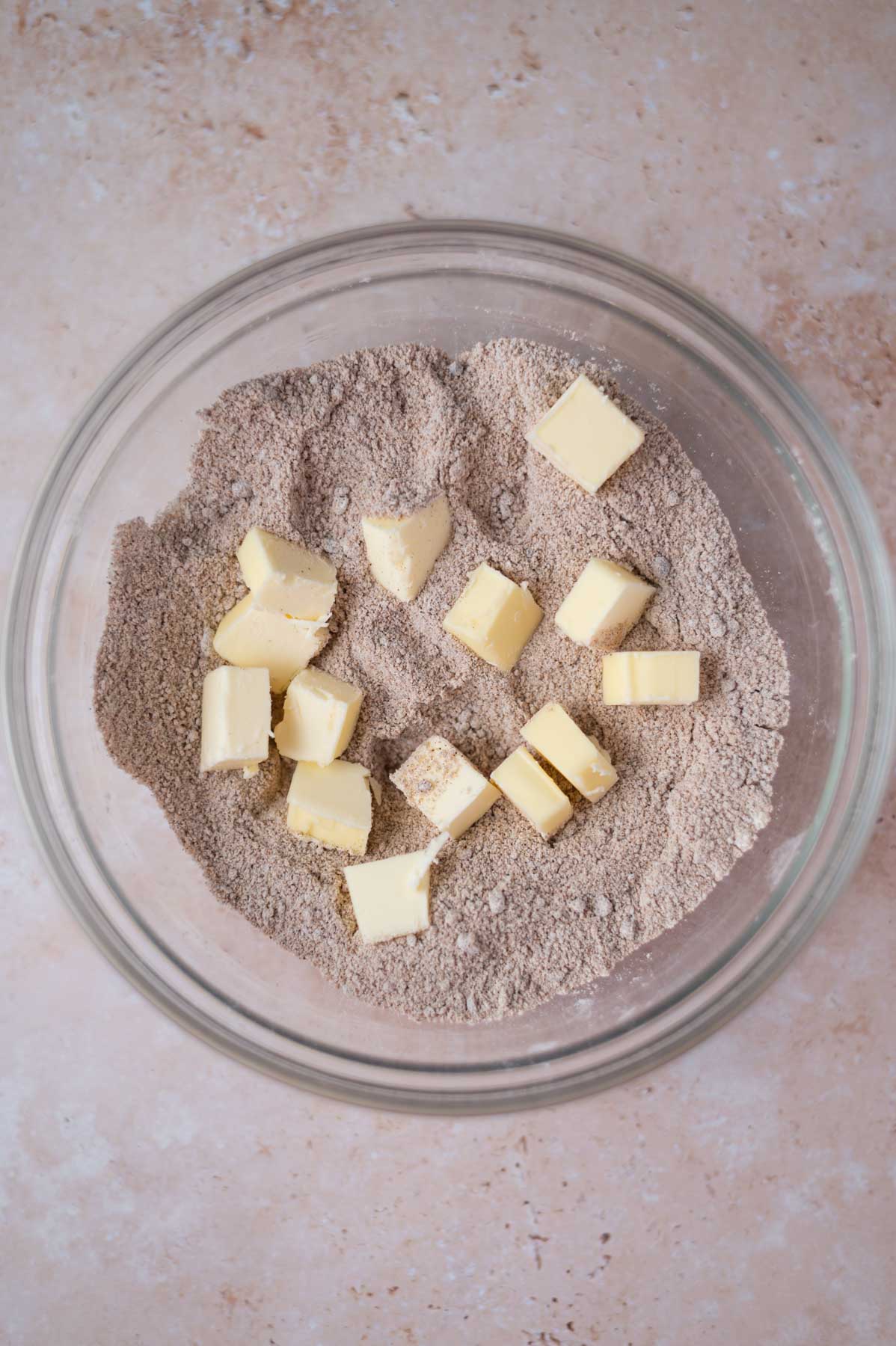 butter chunks in dry streusel ingredients in a bowl