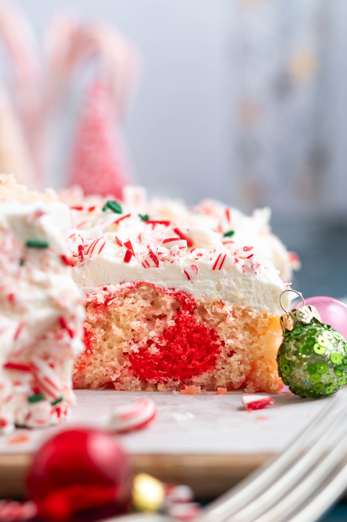 slice of candy cane cake on a cutting board showing the red swirl