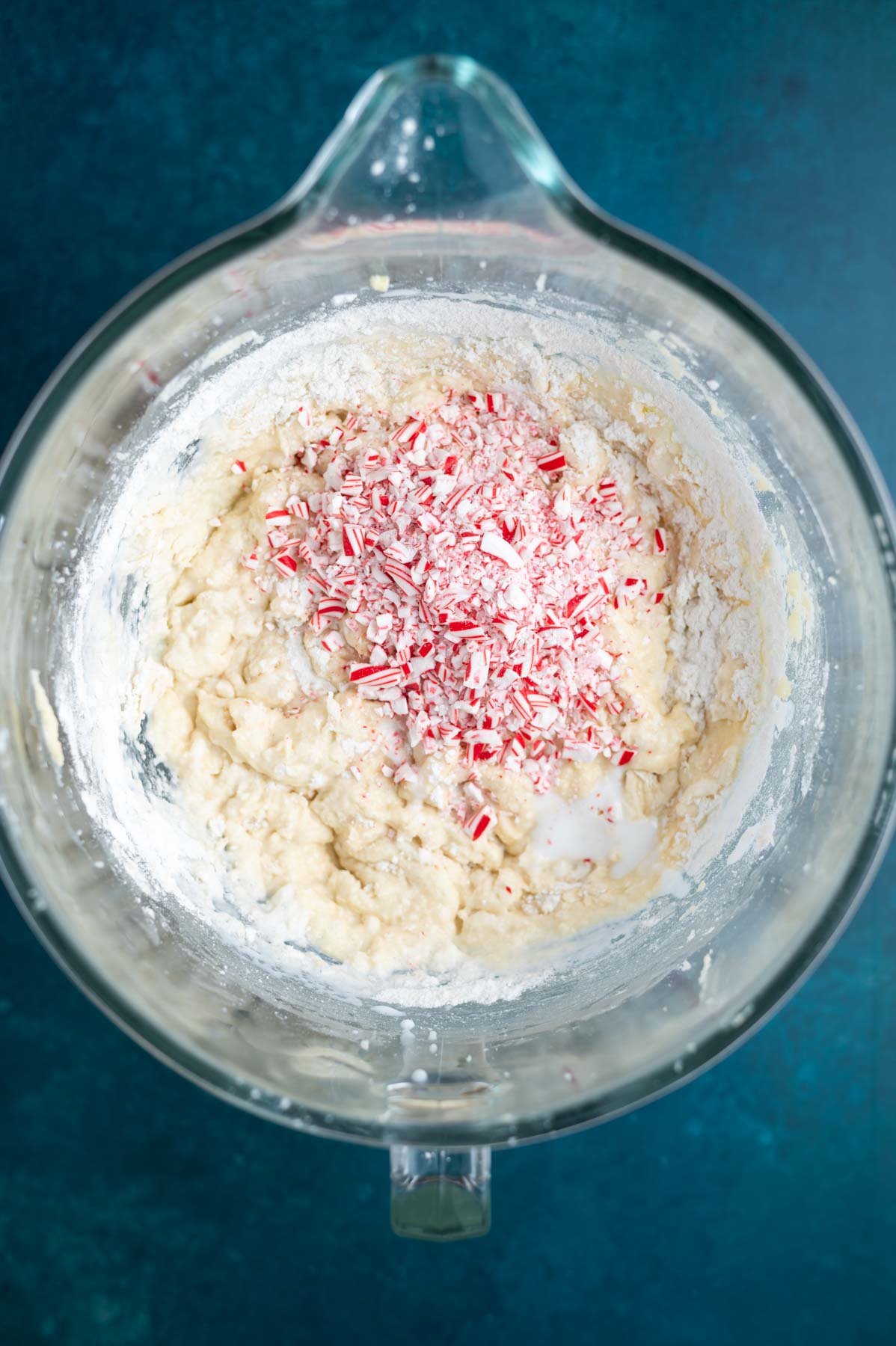 crushed candy canes added to vanilla cake batter in a mixing bowl