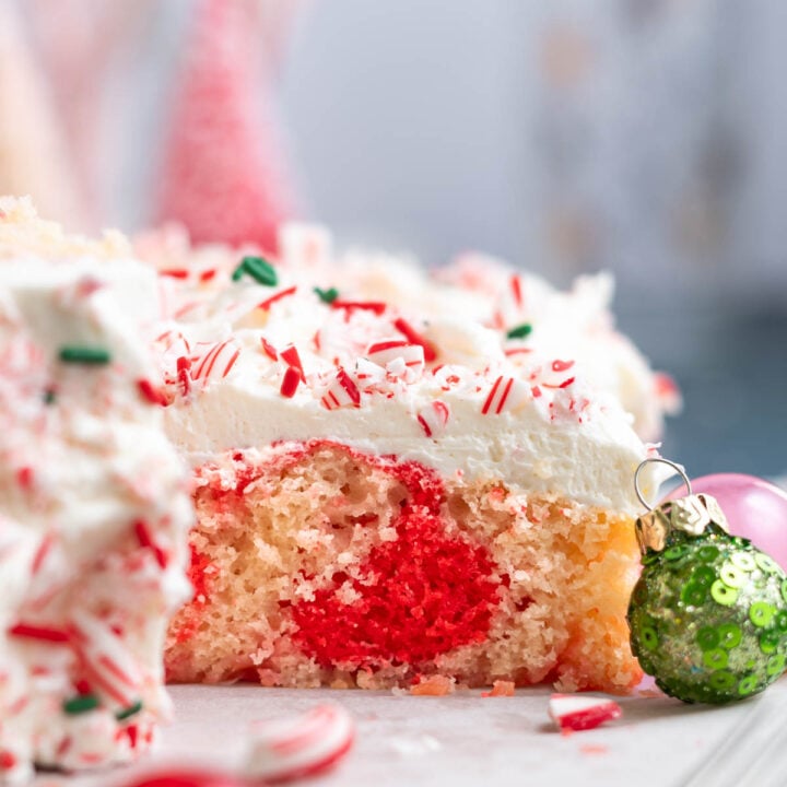 slice of candy cane cake on a cutting board showing the red swirl