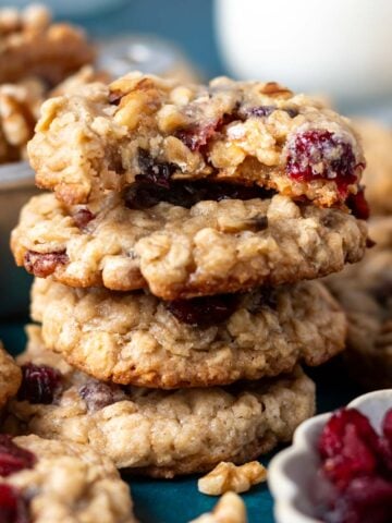 stack of oatmeal cranberry walnut cookies with the top one missing a bite