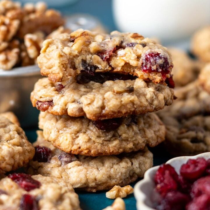 stack of oatmeal cranberry walnut cookies with the top one missing a bite