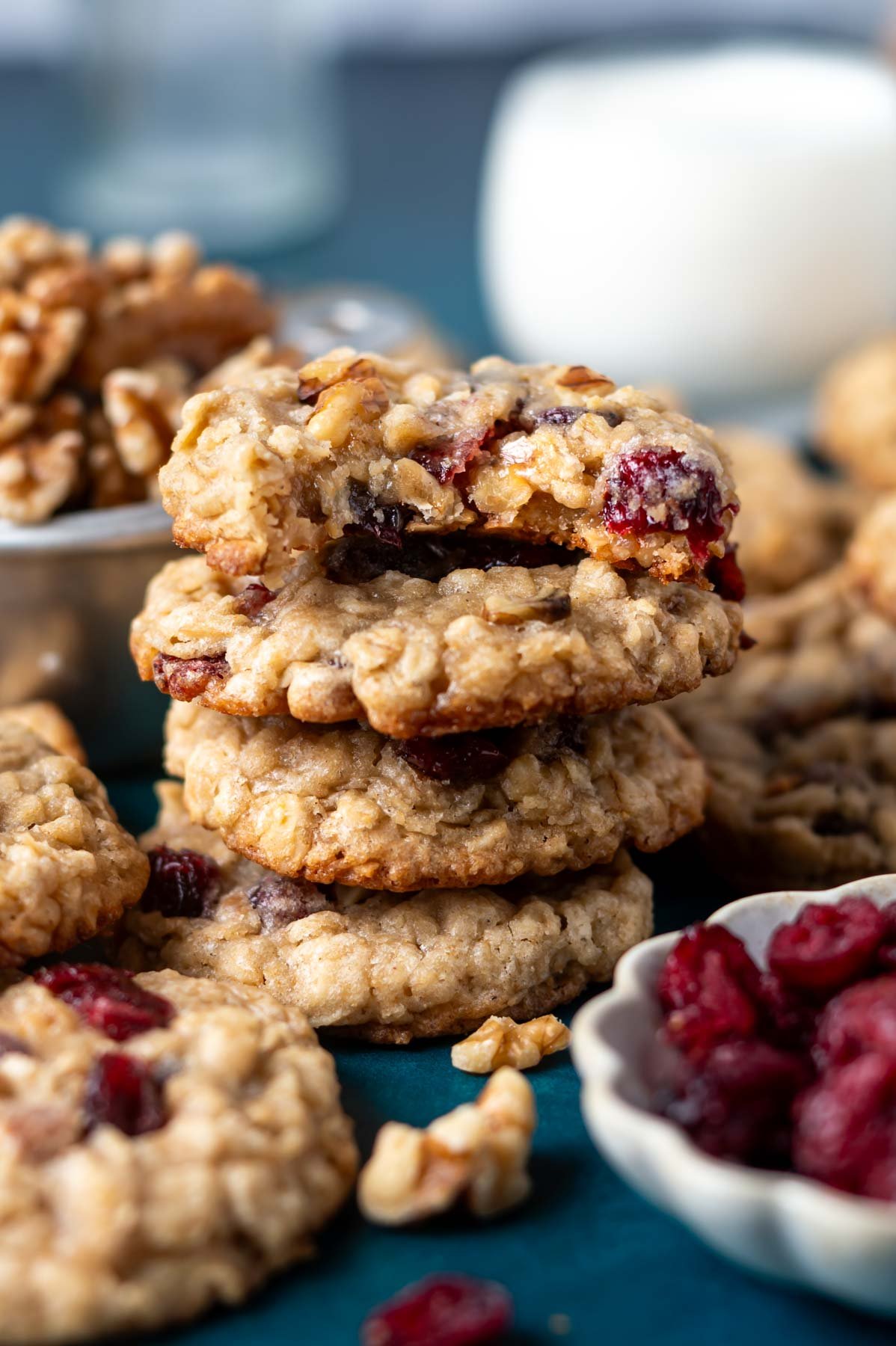 stack of oatmeal cranberry walnut cookies with the top one missing a bite