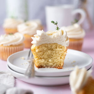 olive oil cupcake half on a plate with a fork; showing soft crumb texture