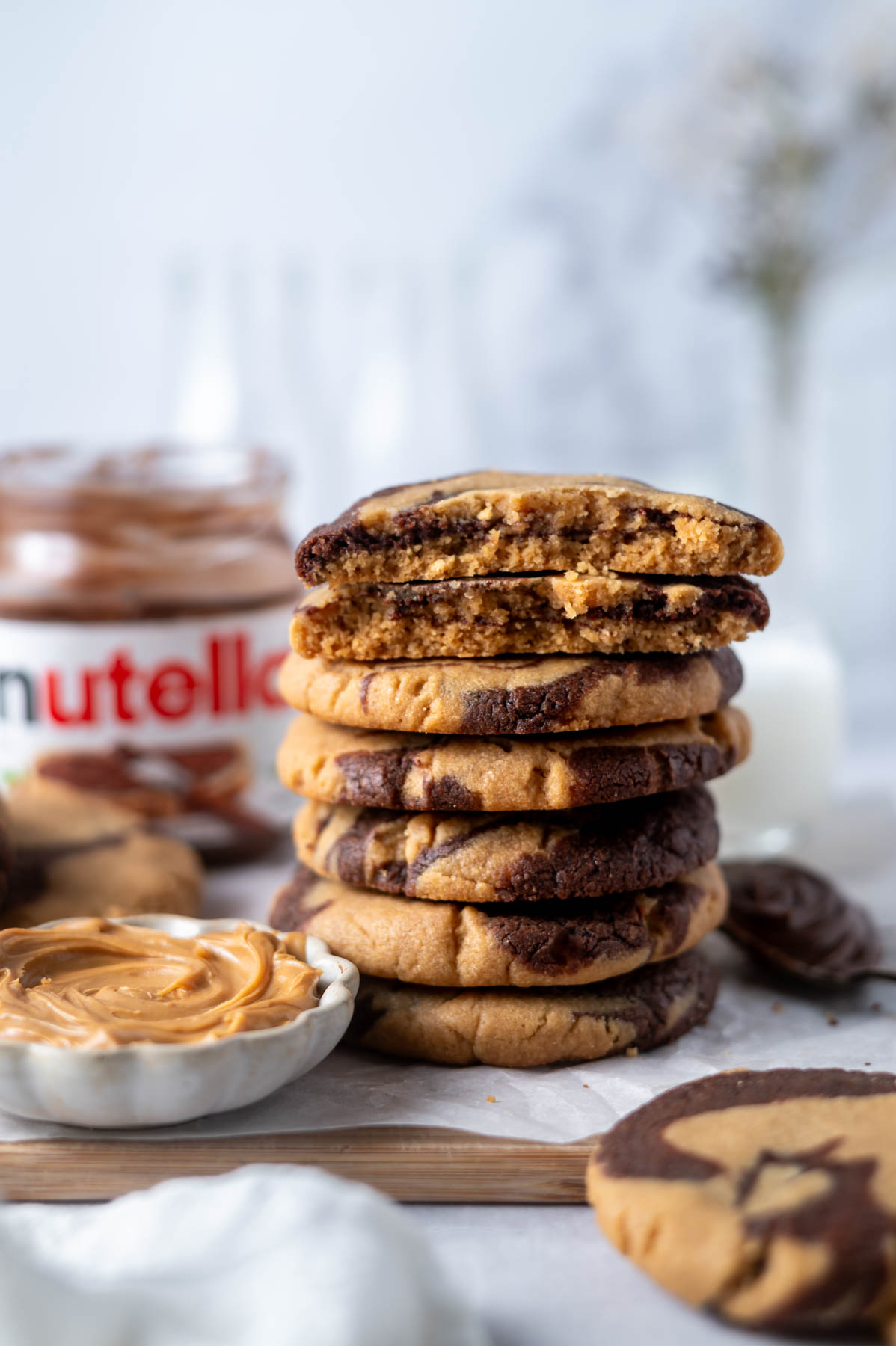 stack of cookies with the top two broken to show the peanut butter nutella swirl