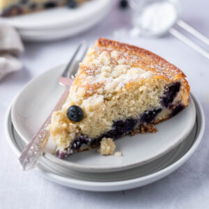 slice of blueberry ricotta cake on a plate with a fork