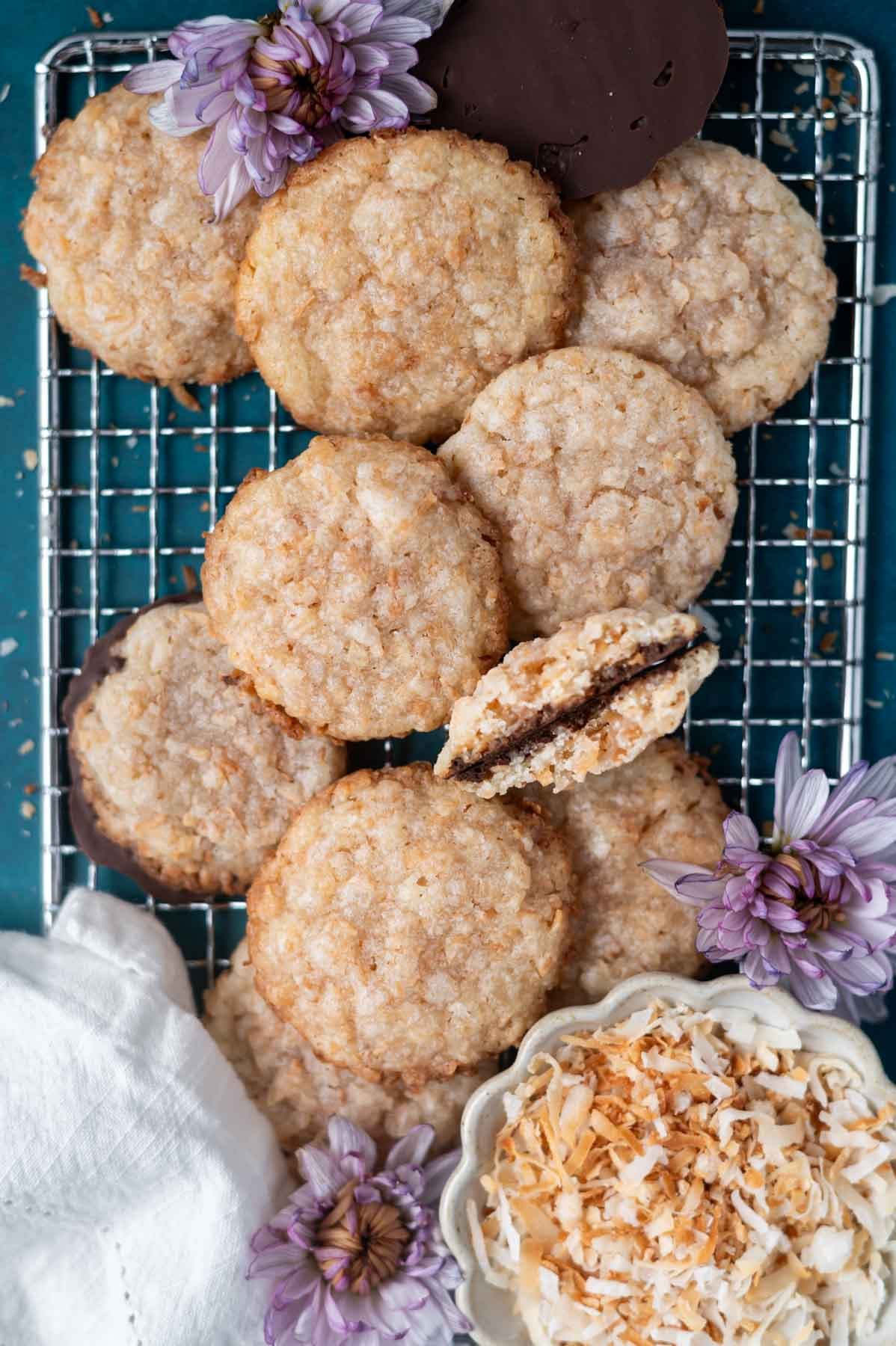 cookies on a cooling rack with a bowl of toasted coconut and flowers