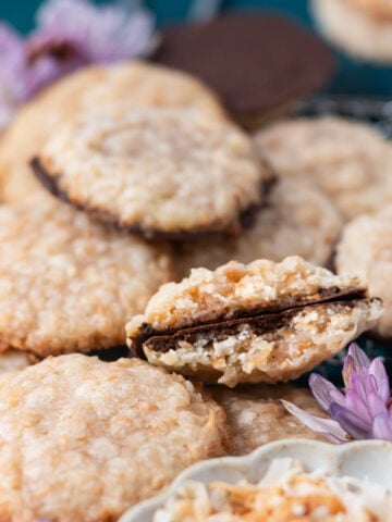 broken crispy coconutcookie, showing thin chocolate coated bottom in a pile of cookies