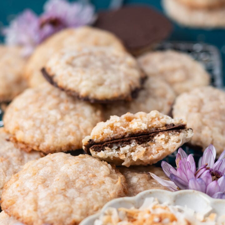 broken crispy coconutcookie, showing thin chocolate coated bottom in a pile of cookies