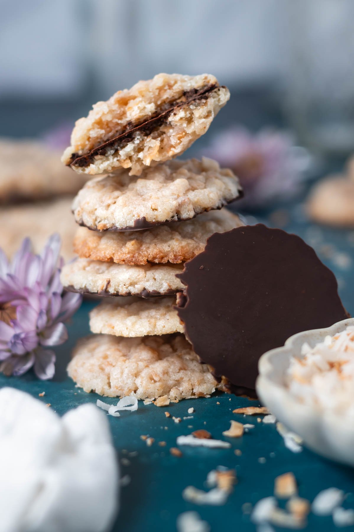 stack of cookies with a cookie showing the chocolate coated bottom leaned against the side