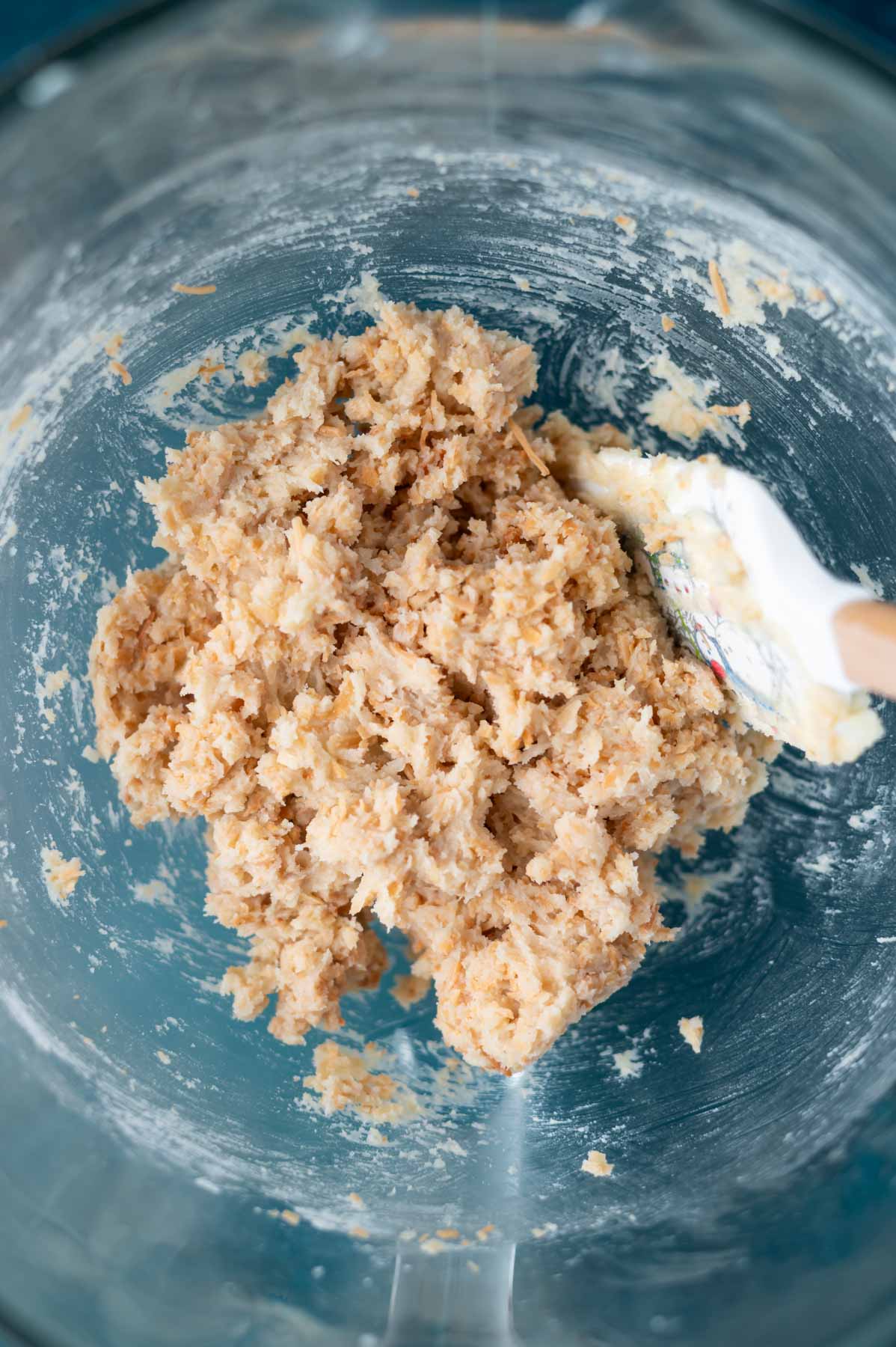 crispy coconut cookie dough in a mixing bowl with a spatula