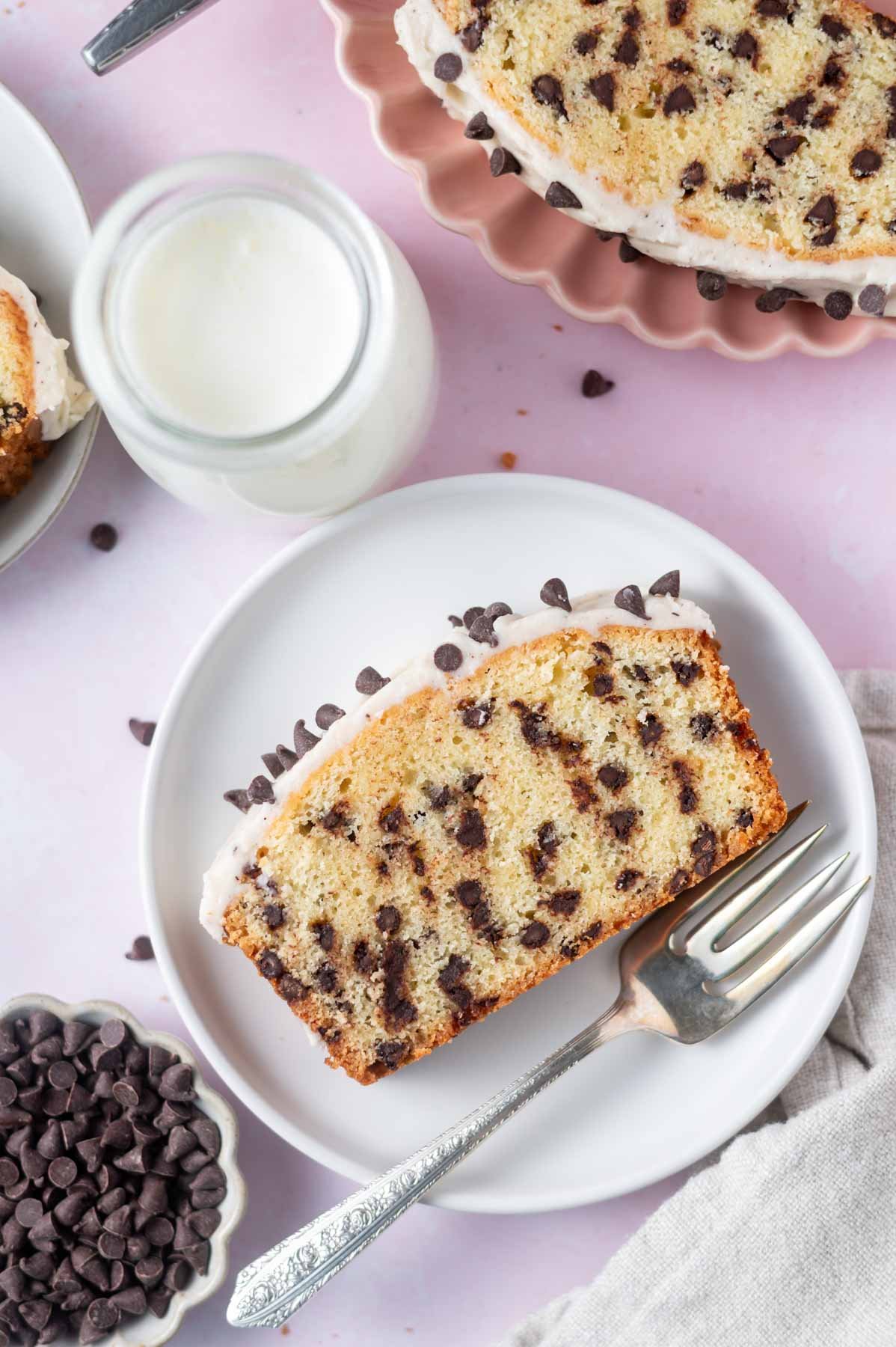 slices of chocolate chip loaf cake on a plates with a fork and a glass of milk