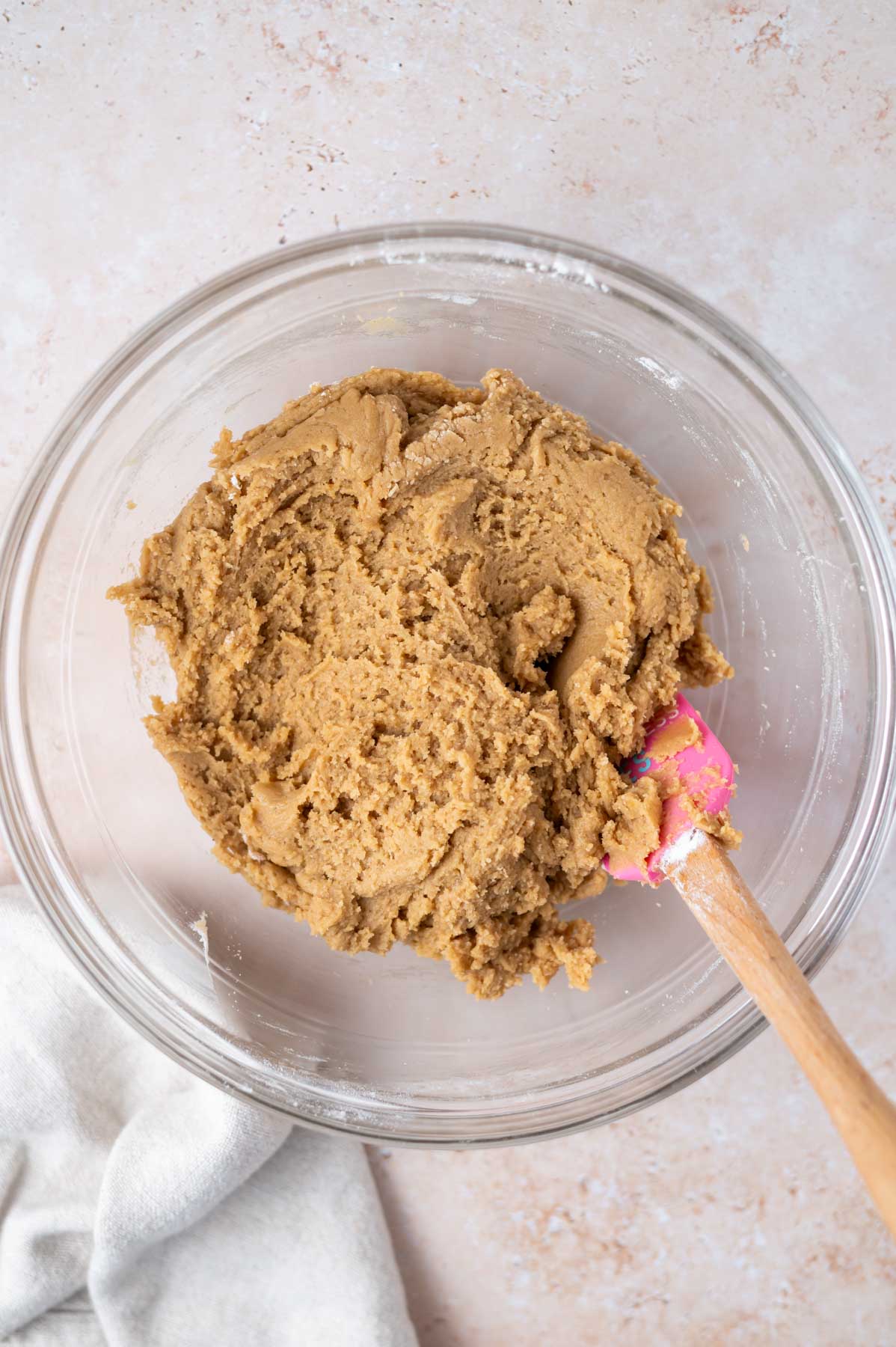 chocolate chipless cookie dough in a glass bowl with a spatula