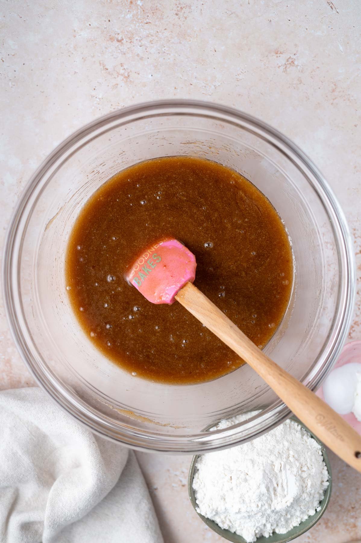 eggs and vanilla mixed into sugar and butter mixture in a bowl with a spatula