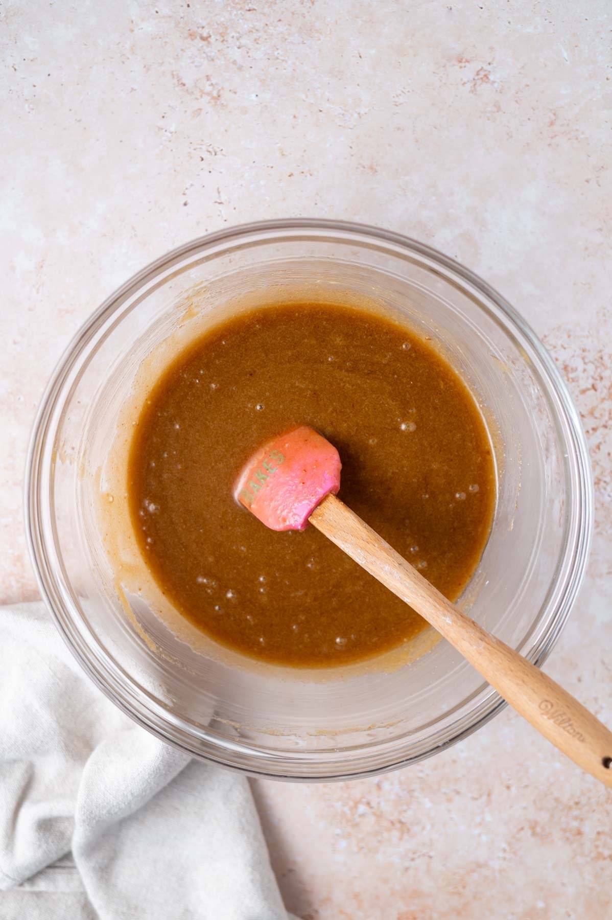 baking soda and cornstarch mixed into cookie dough batter in a bowl with a spatula