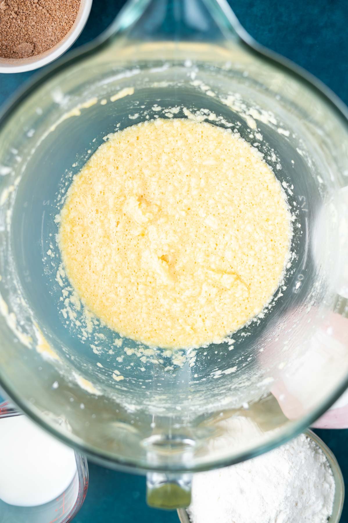 butter, sugar and eggs mixed together in a mixing bowl looking a little curdled