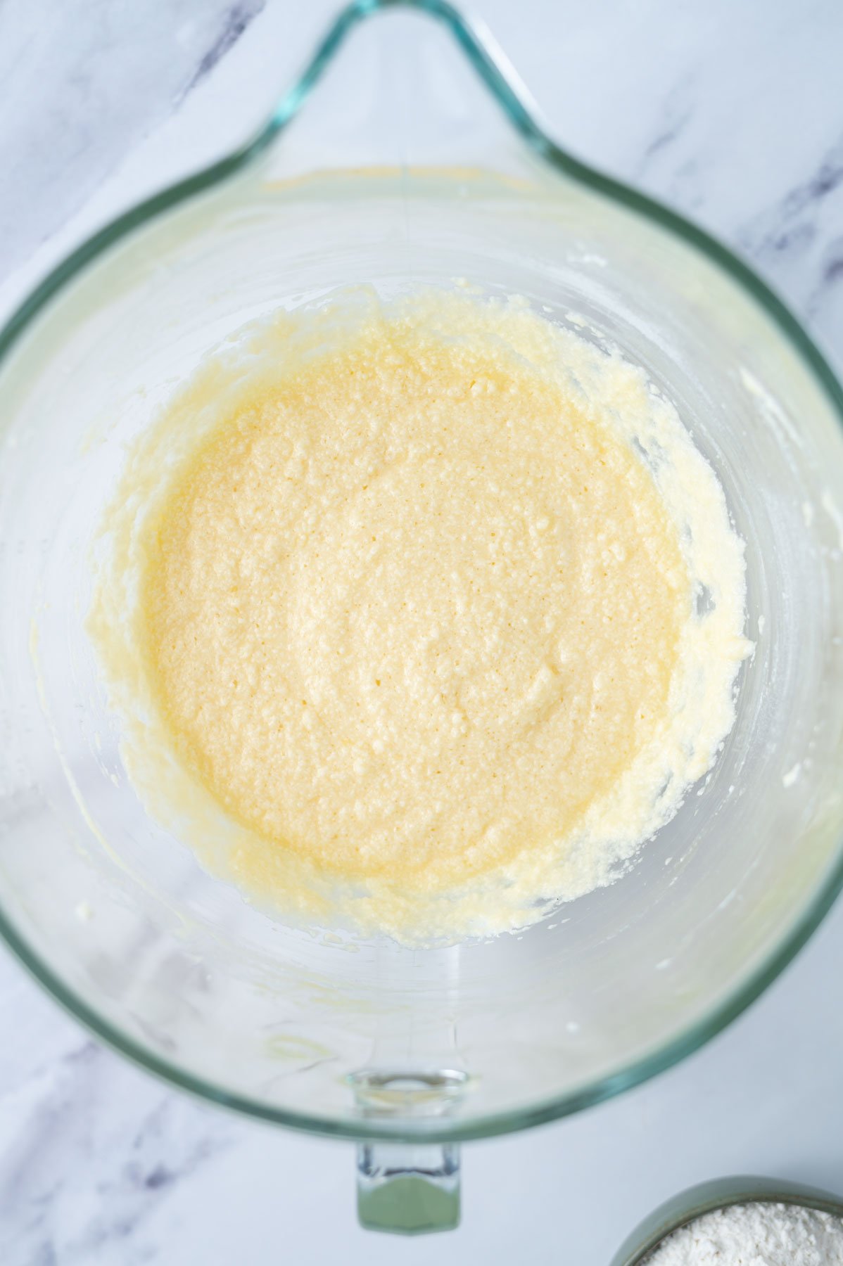cake batter looking slightly curdled after the addition of sour cream and eggs