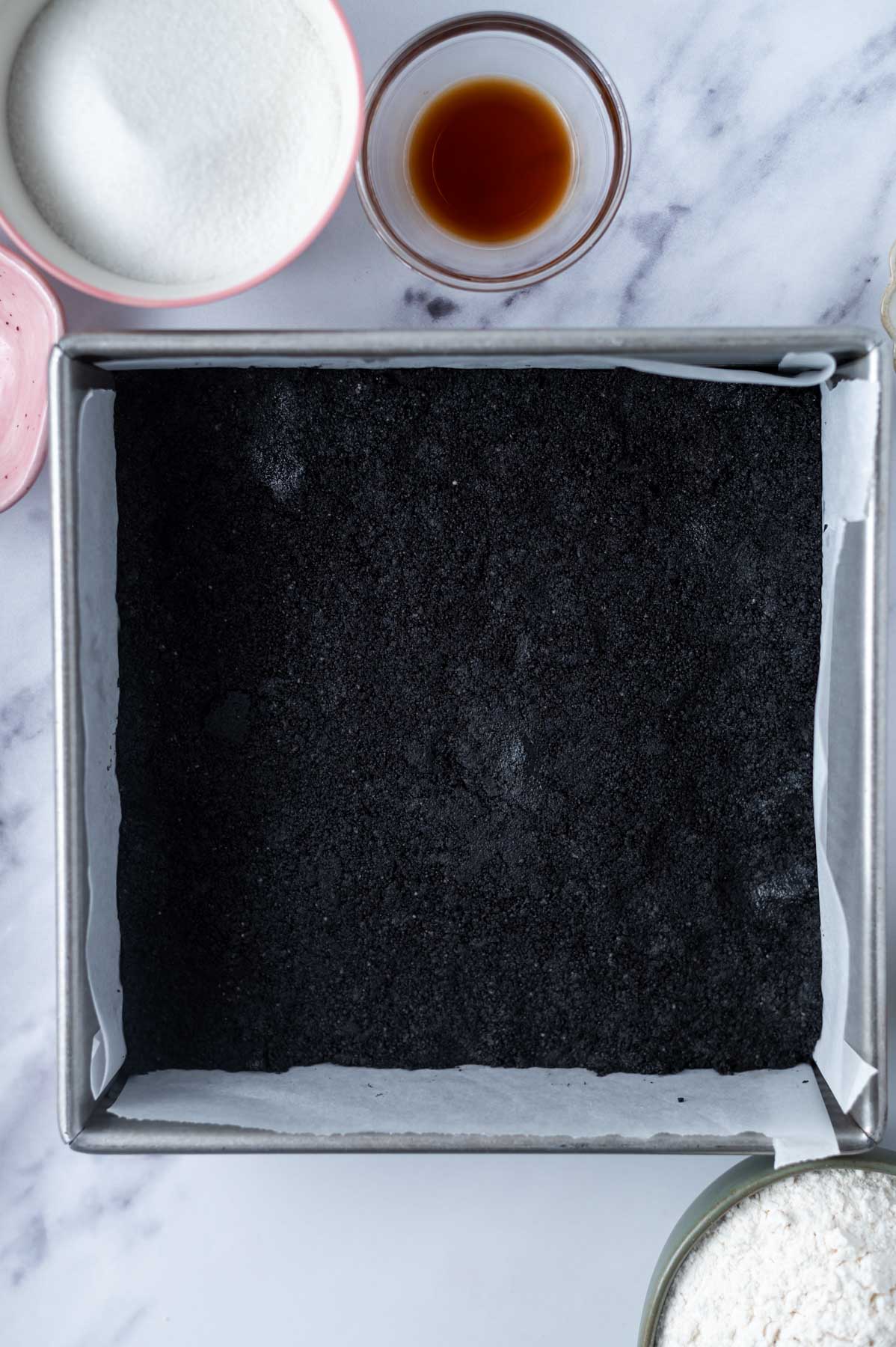 oreo cookie crust in a parchment lined baking tin