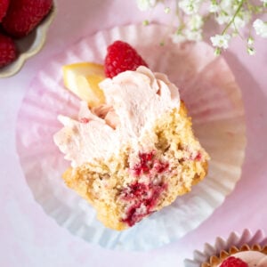 lemon raspberry cupcake cut in half in a cupcake liner showing raspberries through the cupcake