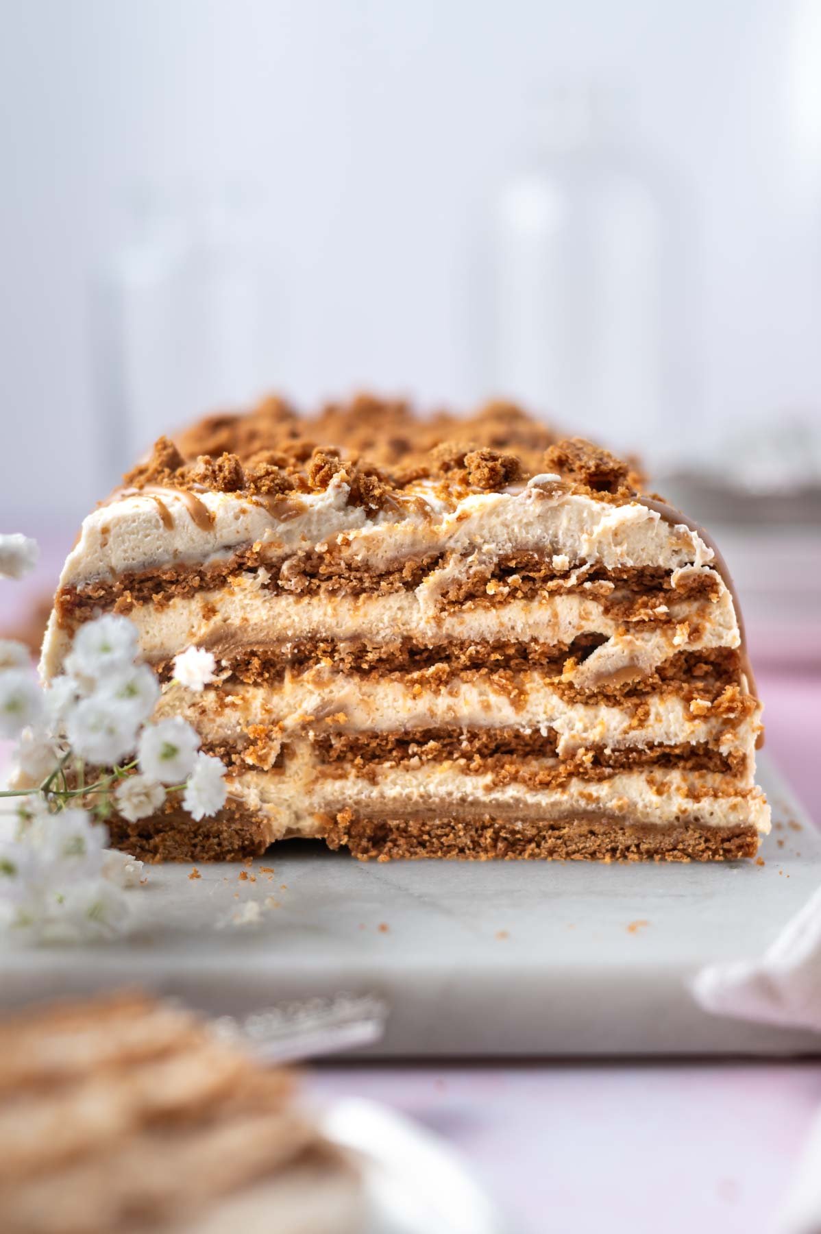 layers of biscoff icebox cake sitting on a marble board