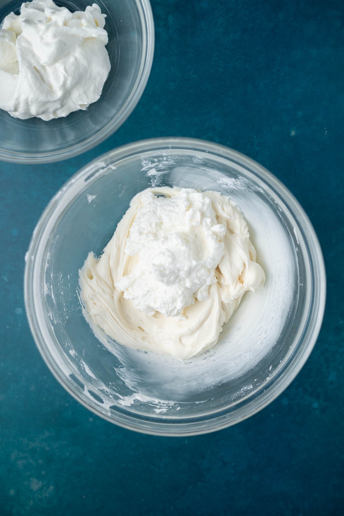 ricotta cheese added to frosting in a bowl