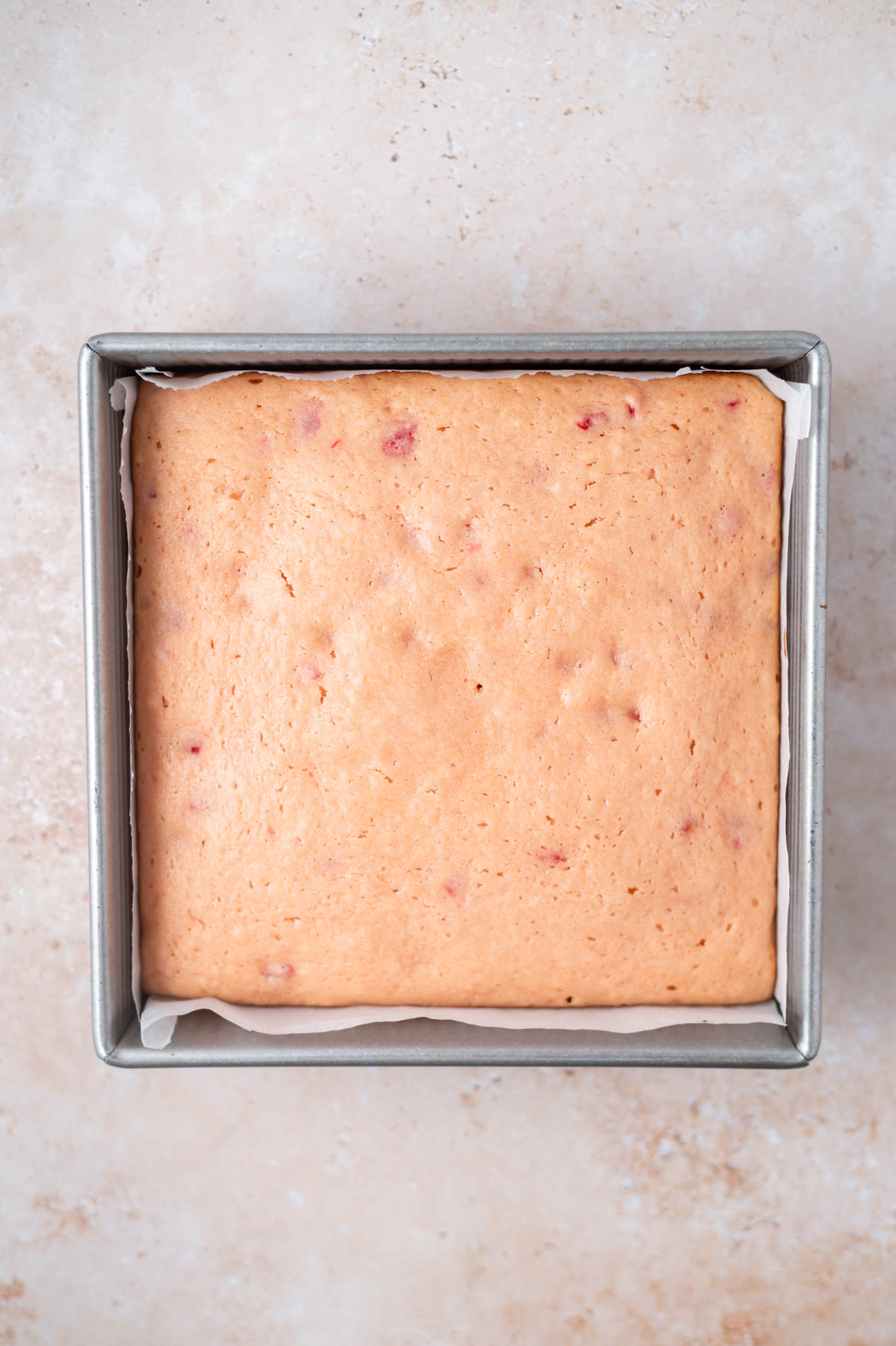 baked cake in a parchment lined baking pan