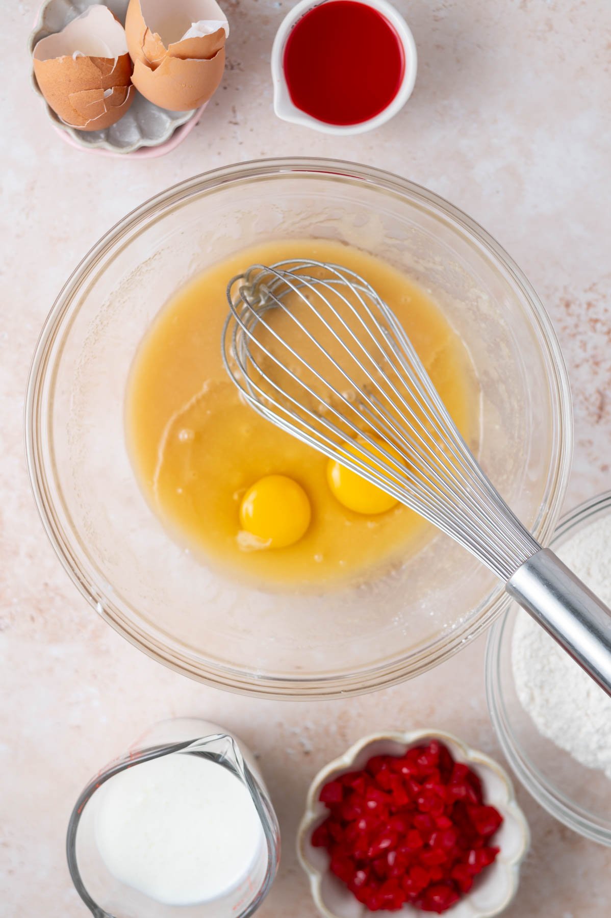 eggs added to melted butter and sugar in a mixing bowl with a whisk
