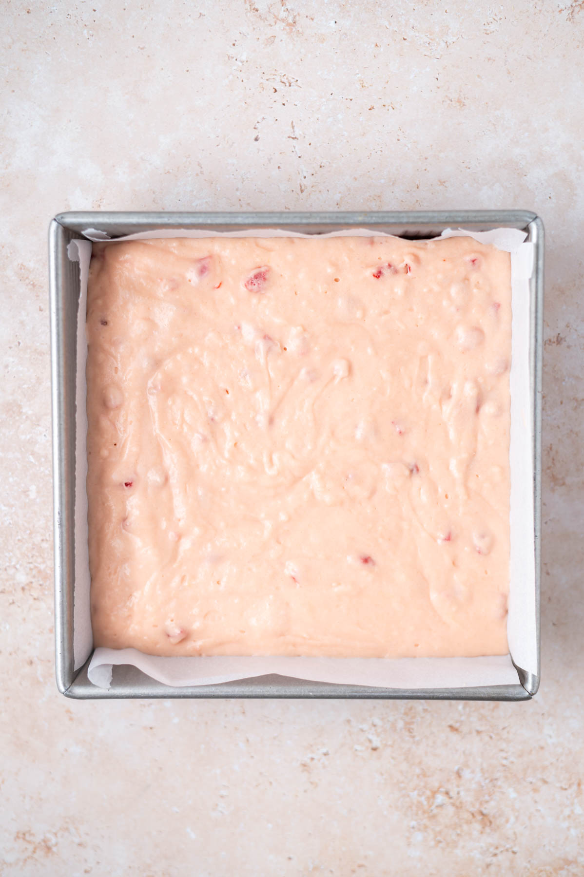 cake batter in a parchment lined baking pan