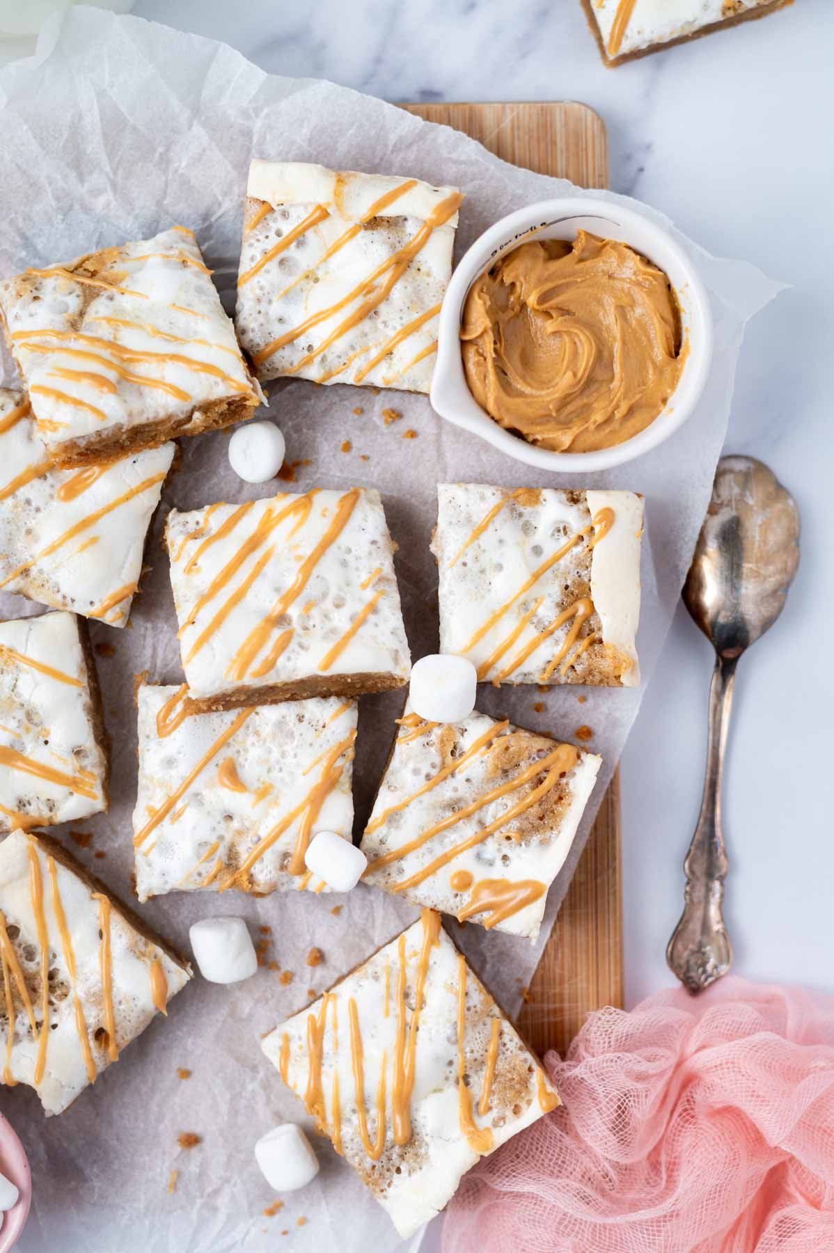 fluffernutter bars cut into slices and on a parchment lined cutting board with a bowl of peanut butter