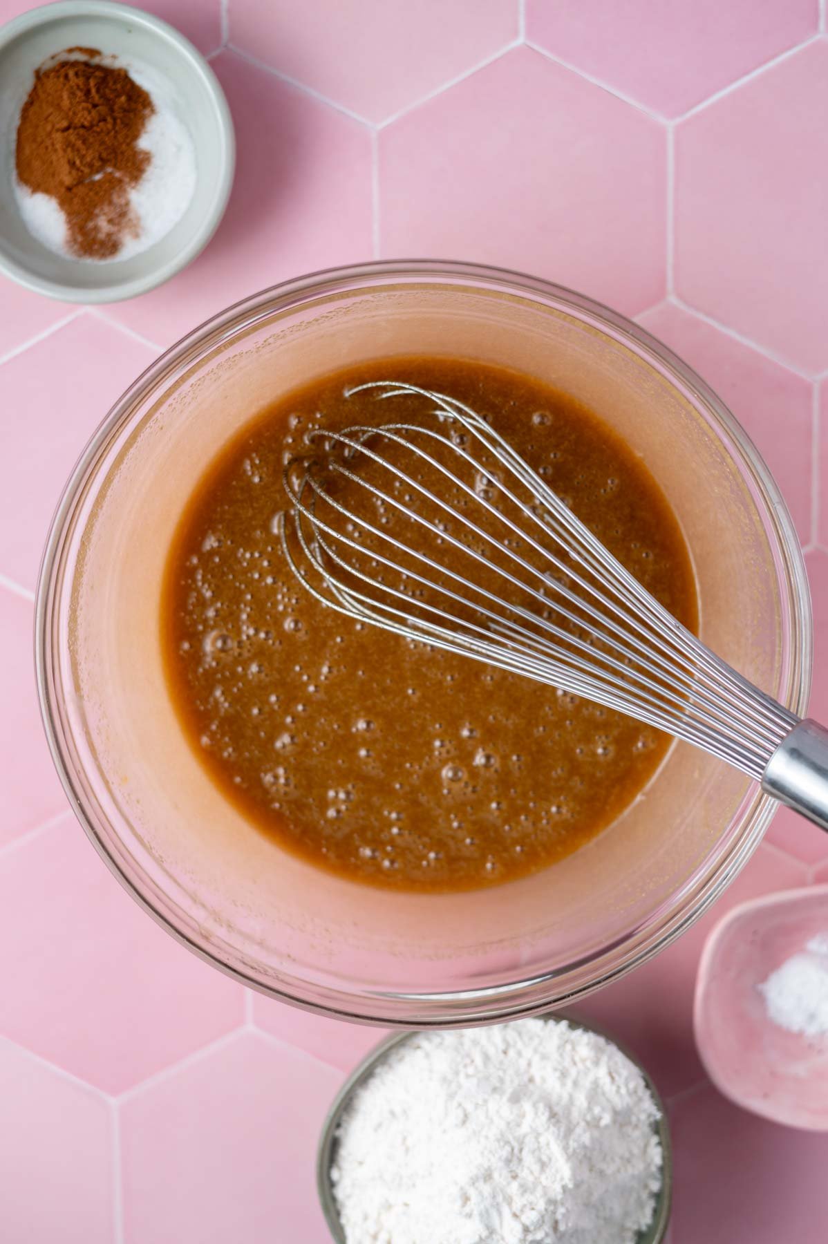 eggs whisked into butter and sugar in a glass bowl with a whisk