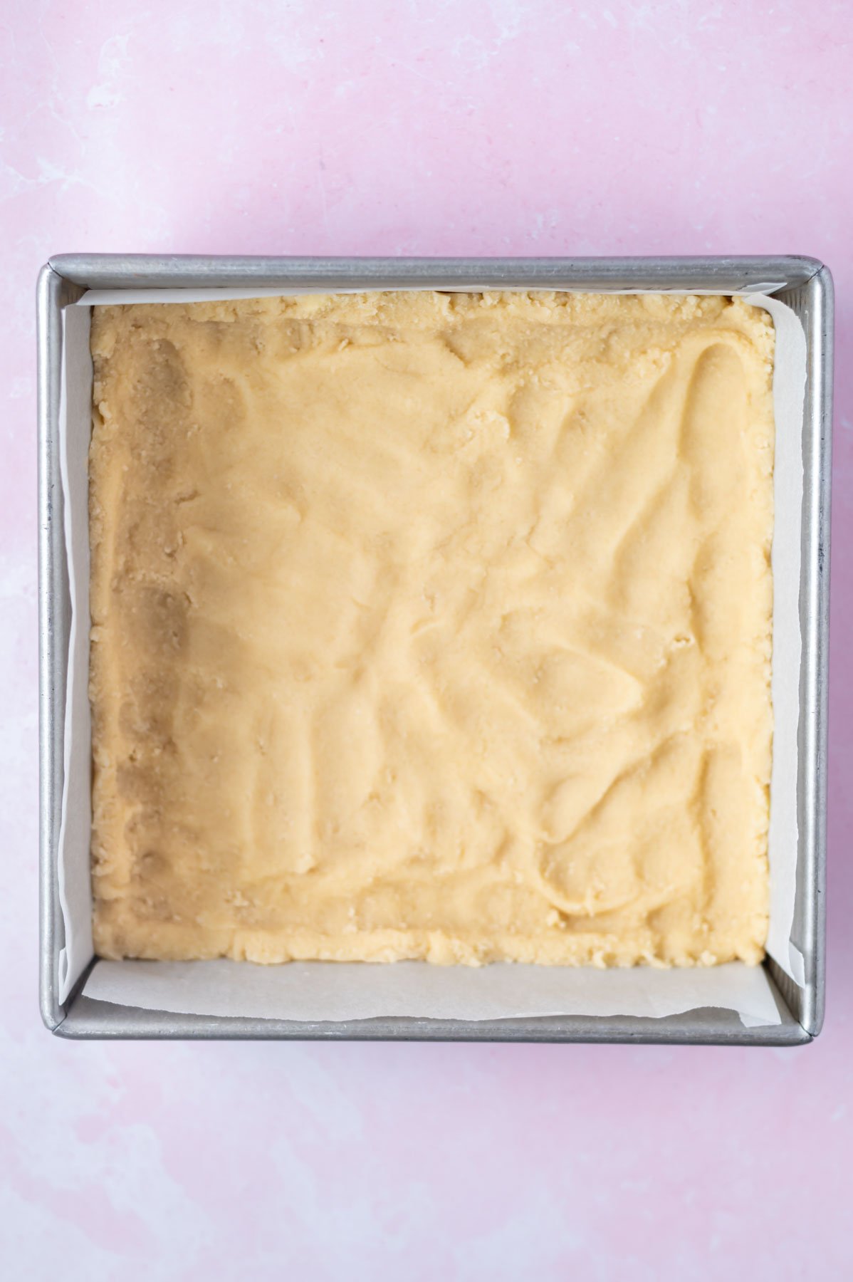 shortbread crust pressed into a parchment lined baking pan
